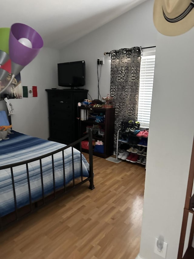 bedroom with lofted ceiling and wood-type flooring