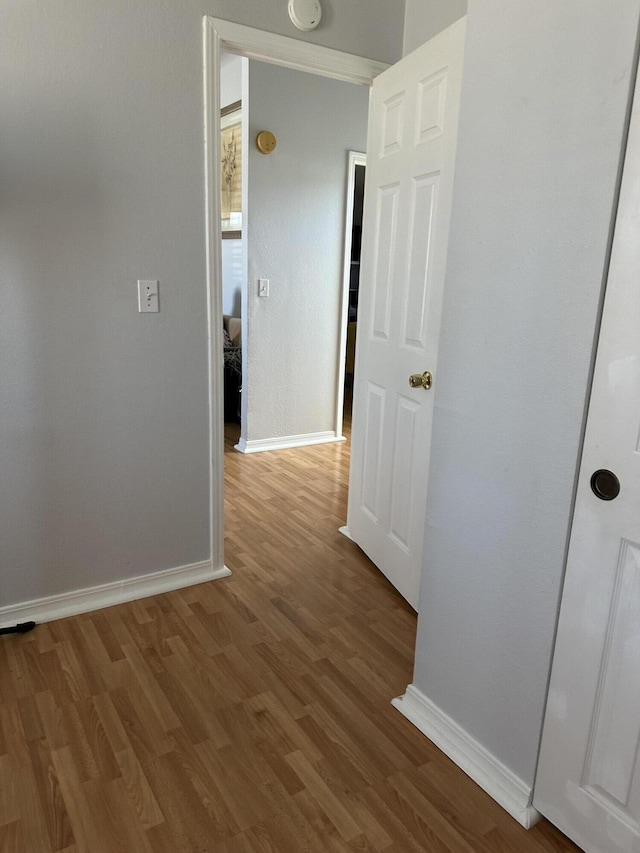 hallway with hardwood / wood-style flooring