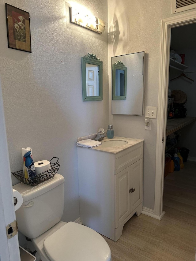 bathroom featuring hardwood / wood-style flooring, vanity, and toilet