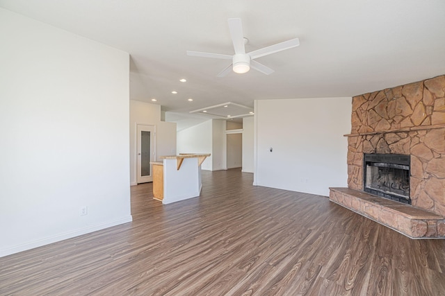 unfurnished living room featuring ceiling fan, a fireplace, and dark hardwood / wood-style floors