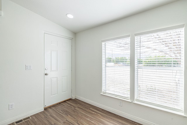 unfurnished room with hardwood / wood-style flooring and lofted ceiling