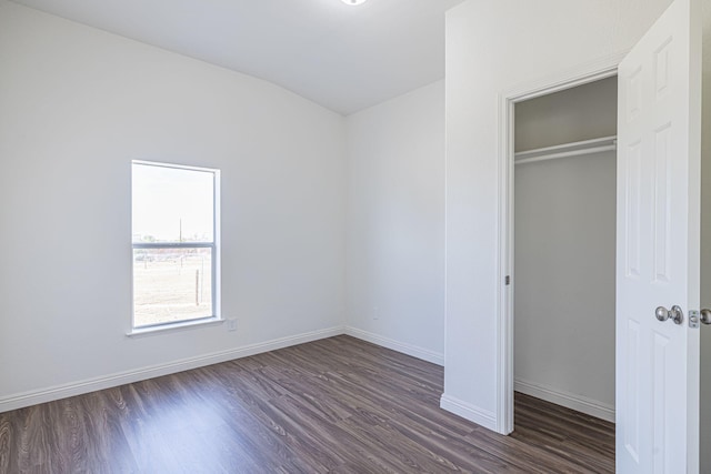 unfurnished bedroom featuring dark hardwood / wood-style floors and a closet