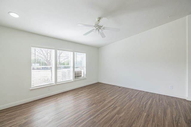 empty room with dark wood-type flooring and ceiling fan