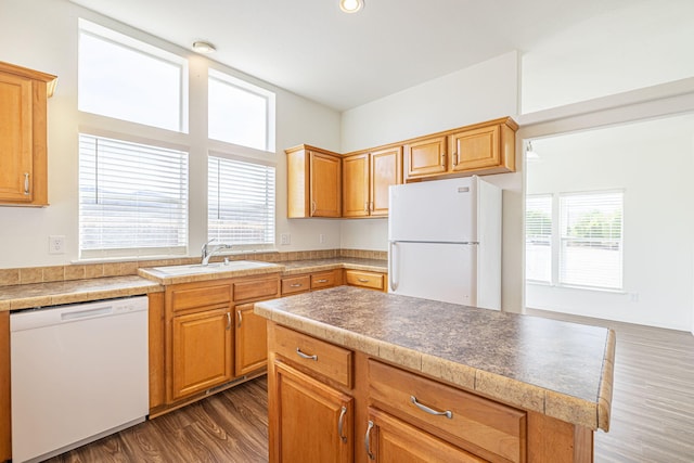 kitchen with a kitchen island, sink, dark wood-type flooring, and white appliances