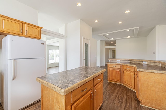 kitchen featuring white refrigerator, a kitchen island, and dark hardwood / wood-style floors