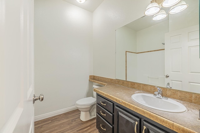 bathroom with vanity, wood-type flooring, and toilet