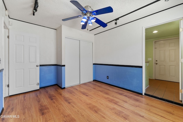 45503 Lorimer Ave, Lancaster, CA 93534 - empty room with ceiling fan, wood finished floors, a textured ceiling, and rail lighting