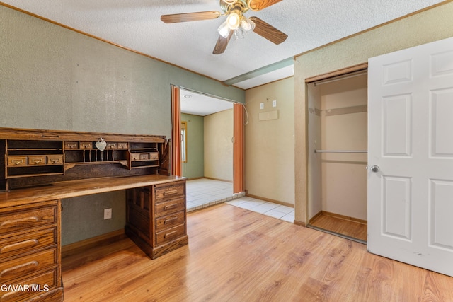 45503 Lorimer Ave, Lancaster, CA 93534 - unfurnished office featuring light wood finished floors, ceiling fan, built in desk, and a textured ceiling
