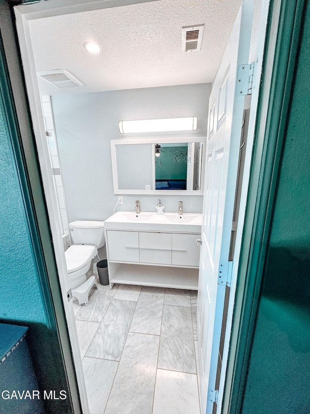 2895 59th St, Rosamond, CA 93560 - bathroom with double vanity, marble finish flooring, and a textured ceiling