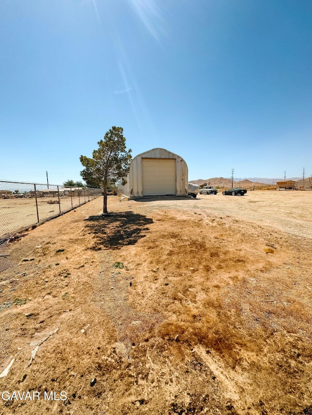 2895 59th St, Rosamond, CA 93560 - view of yard with a garage, an outdoor structure, and a rural view