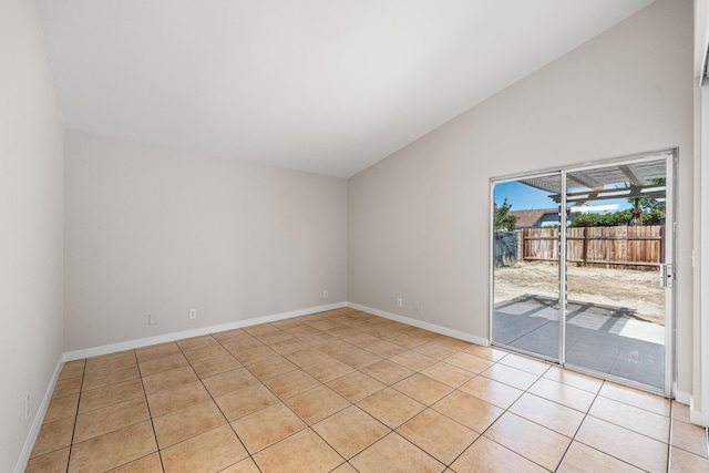 unfurnished room featuring light tile patterned floors, vaulted ceiling, and baseboards