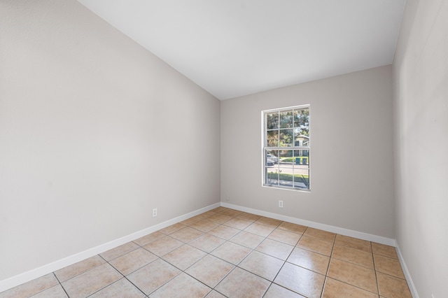 empty room with light tile patterned floors and baseboards