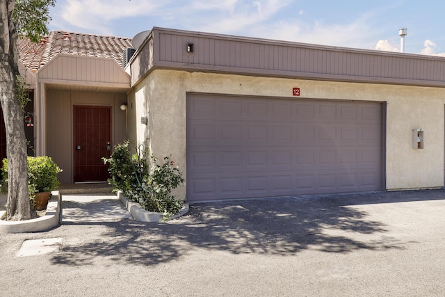 43334 W 32nd St Unit 12, Lancaster, CA 93536 - view of front of home with stucco siding, asphalt driveway, and a garage