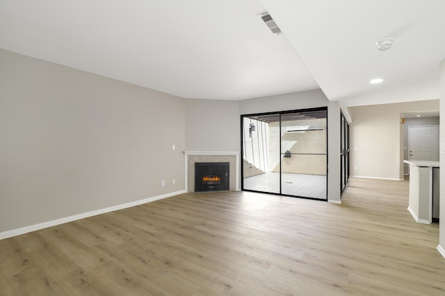 43334 W 32nd St Unit 12, Lancaster, CA 93536 - unfurnished living room with light wood finished floors, baseboards, a lit fireplace, and recessed lighting