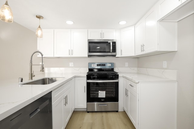 43334 W 32nd St Unit 12, Lancaster, CA 93536 - kitchen with appliances with stainless steel finishes, a sink, light stone countertops, white cabinetry, and recessed lighting