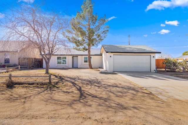 single story home featuring concrete driveway, fence, an attached garage, and stucco siding