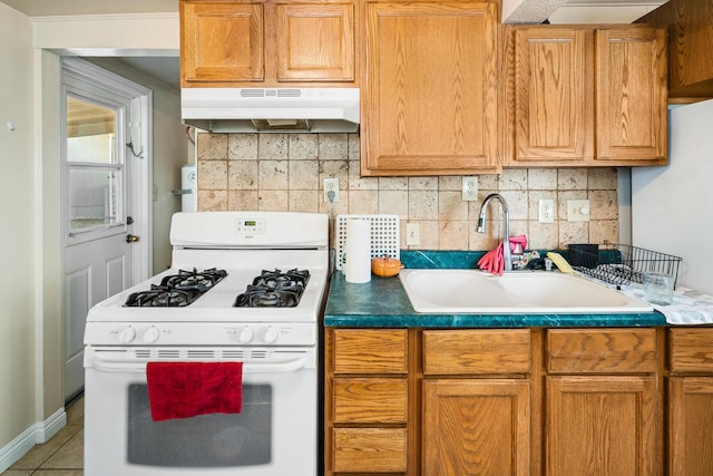 kitchen featuring backsplash, tile patterned floors, white range with gas cooktop, and sink