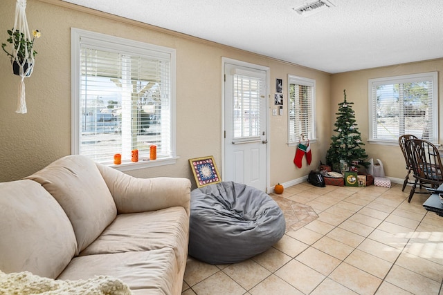 tiled living room featuring a textured ceiling