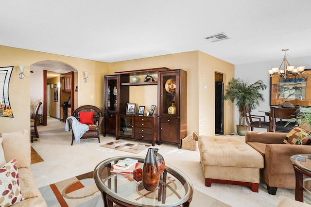 living room featuring light carpet and an inviting chandelier