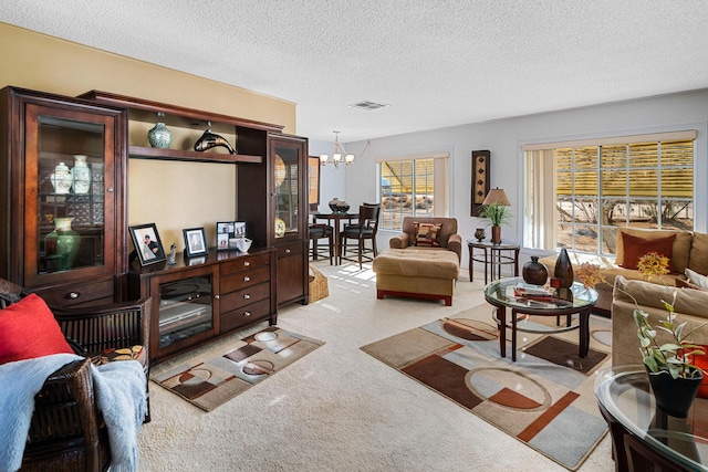 carpeted living room featuring a textured ceiling and a notable chandelier