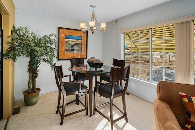 carpeted dining area featuring a chandelier and a textured ceiling