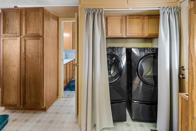 clothes washing area featuring cabinets and independent washer and dryer