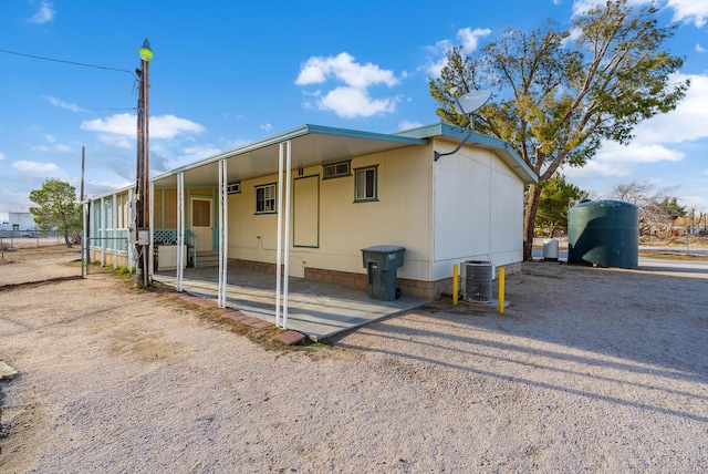 rear view of house with central AC and a carport