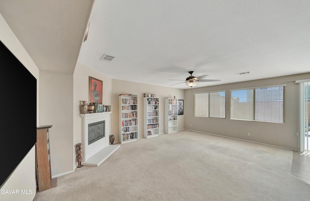 2354 Crimson Ave, Rosamond, CA 93560 - unfurnished living room featuring a glass covered fireplace, ceiling fan, and light colored carpet