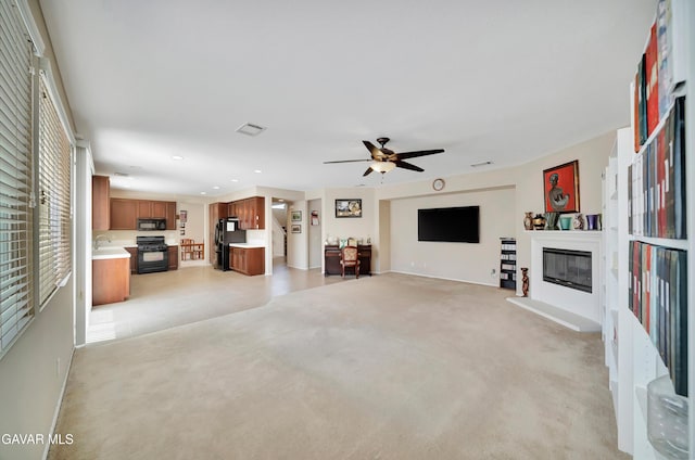 2354 Crimson Ave, Rosamond, CA 93560 - unfurnished living room featuring a glass covered fireplace, recessed lighting, a ceiling fan, and light colored carpet