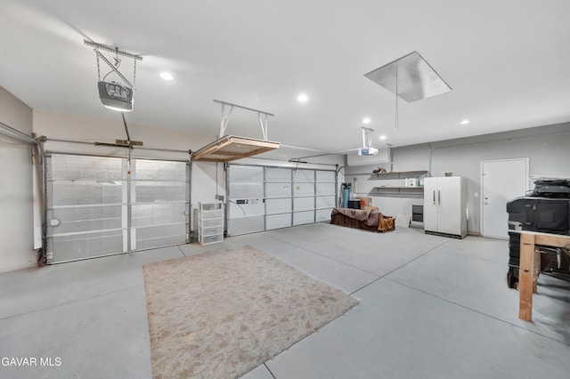 2354 Crimson Ave, Rosamond, CA 93560 - garage with a garage door opener, freestanding refrigerator, and recessed lighting