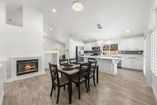 37116 Alder St, Palmdale, CA 93552 - dining room featuring lofted ceiling, light wood-type flooring, a glass covered fireplace, and recessed lighting