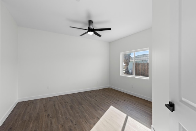 empty room with ceiling fan and dark hardwood / wood-style flooring