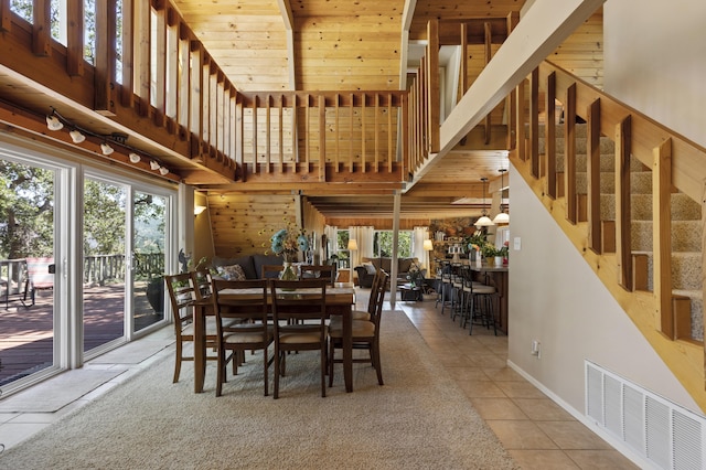 tiled dining space featuring a towering ceiling