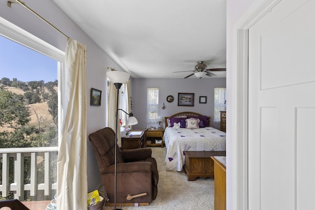 bedroom featuring ceiling fan, light carpet, and multiple windows