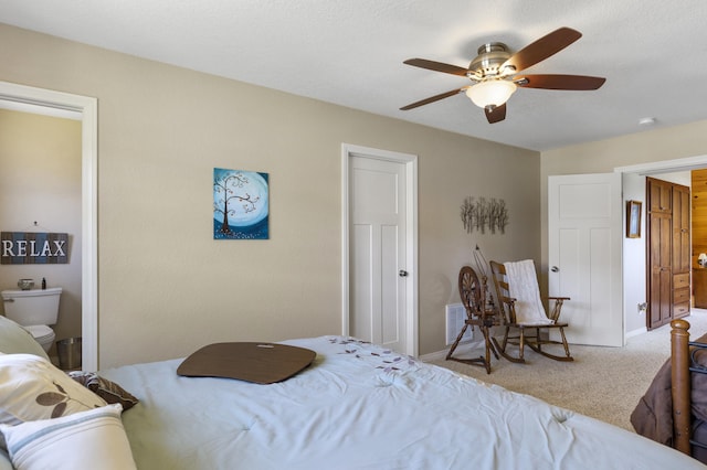 bedroom featuring ensuite bathroom, carpet flooring, and ceiling fan