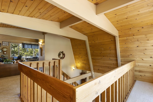 hallway with light colored carpet, wooden ceiling, wooden walls, and vaulted ceiling with beams