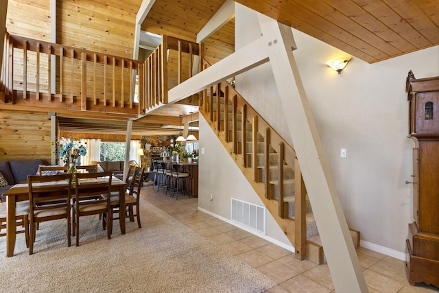 dining space featuring tile patterned flooring, a high ceiling, and wood ceiling