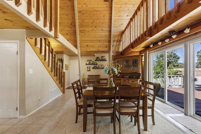 tiled dining area with beamed ceiling, a high ceiling, and wooden ceiling