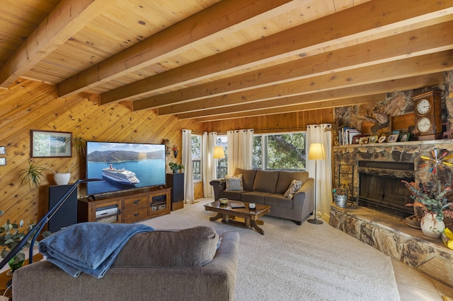 living room featuring carpet flooring, wooden walls, beam ceiling, and a stone fireplace