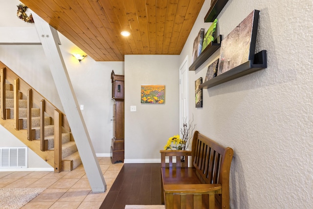 stairs with tile patterned flooring and wood ceiling