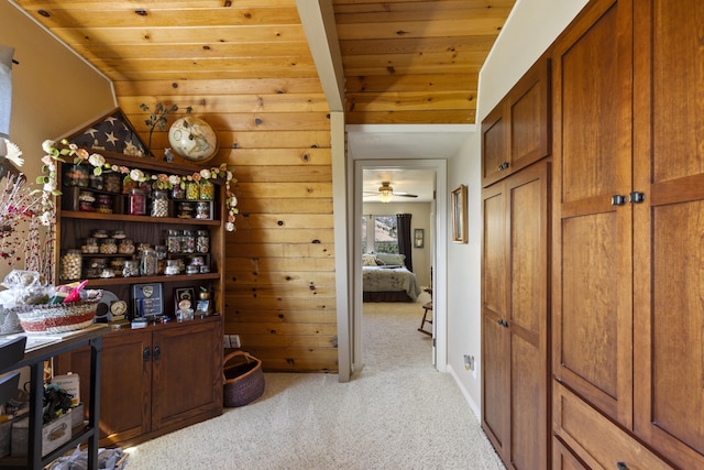 hall featuring lofted ceiling, light colored carpet, and wooden ceiling