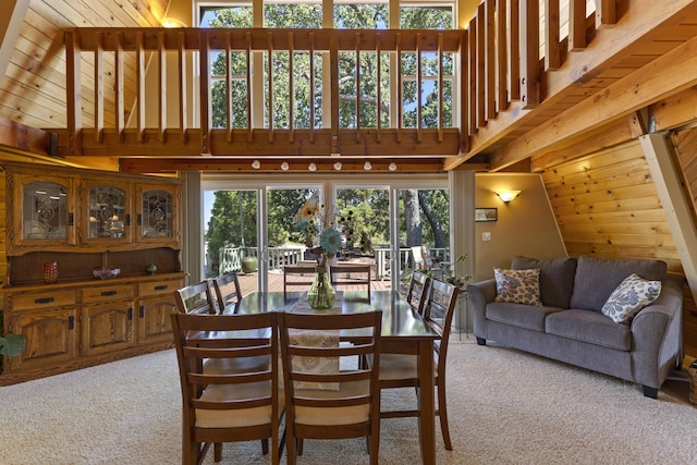 carpeted dining space with lofted ceiling and wood ceiling