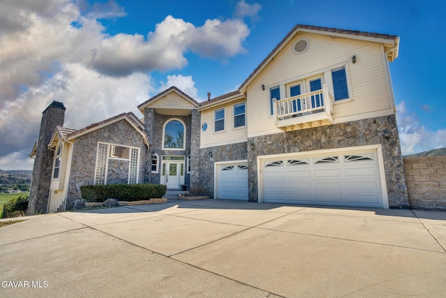 9250 Elizabeth Lake Rd, Leona Valley, CA 93551 - view of front of house with stone siding, a balcony, an attached garage, and driveway
