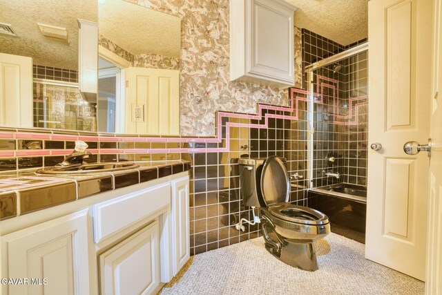 9250 Elizabeth Lake Rd, Leona Valley, CA 93551 - full bathroom featuring a textured ceiling, wallpapered walls, vanity, tub / shower combination, and tile walls