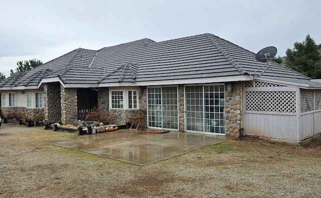 rear view of property with a patio and stone siding