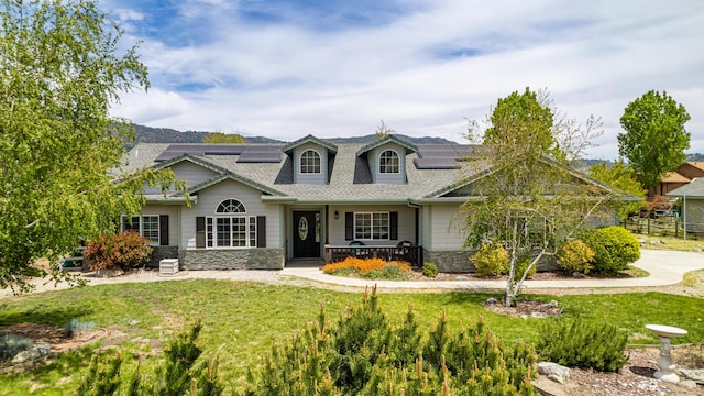 23600 Dart Dr, Tehachapi, CA 93561 - view of front of property featuring stone siding, covered porch, solar panels, and a front lawn
