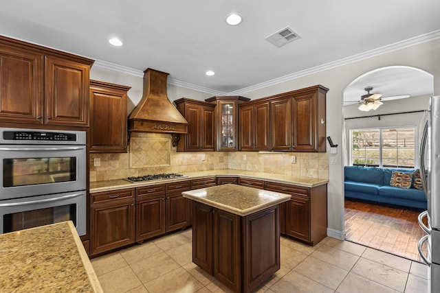 23600 Dart Dr, Tehachapi, CA 93561 - kitchen featuring custom exhaust hood, stainless steel appliances, ceiling fan, light tile patterned floors, and tasteful backsplash
