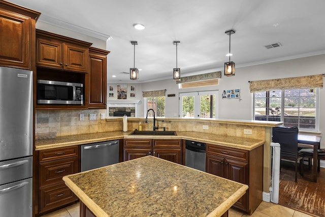 23600 Dart Dr, Tehachapi, CA 93561 - kitchen featuring appliances with stainless steel finishes, a sink, a peninsula, ornamental molding, and tasteful backsplash