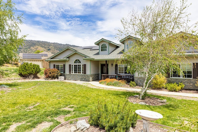 23600 Dart Dr, Tehachapi, CA 93561 - view of front facade with stone siding, a porch, a front lawn, and roof mounted solar panels