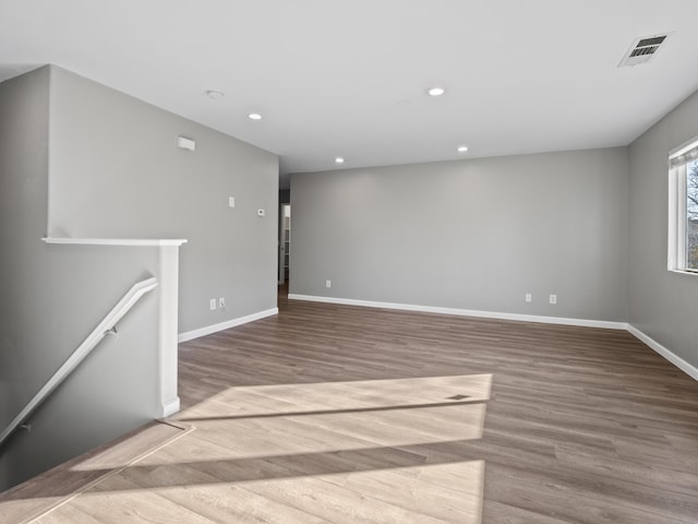 spare room with recessed lighting, wood finished floors, visible vents, and baseboards